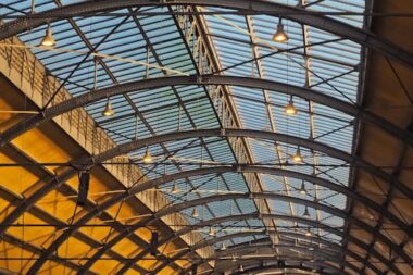 Detailed view of a futuristic glass and steel arched ceiling with geometric design.